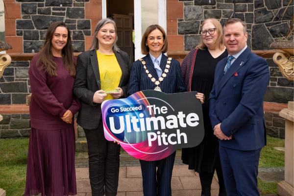 5 people holding up an Ultimate Pitch board
